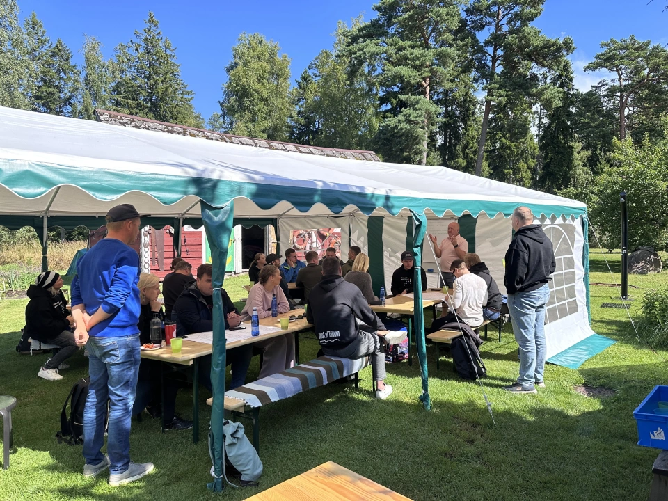 Töötuba välitingimustes — osalejad telgi all laudade taga